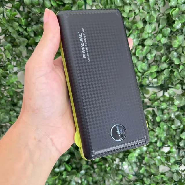 Power Bank AJ-C04 segurado na mão; foto real do produto fornecida